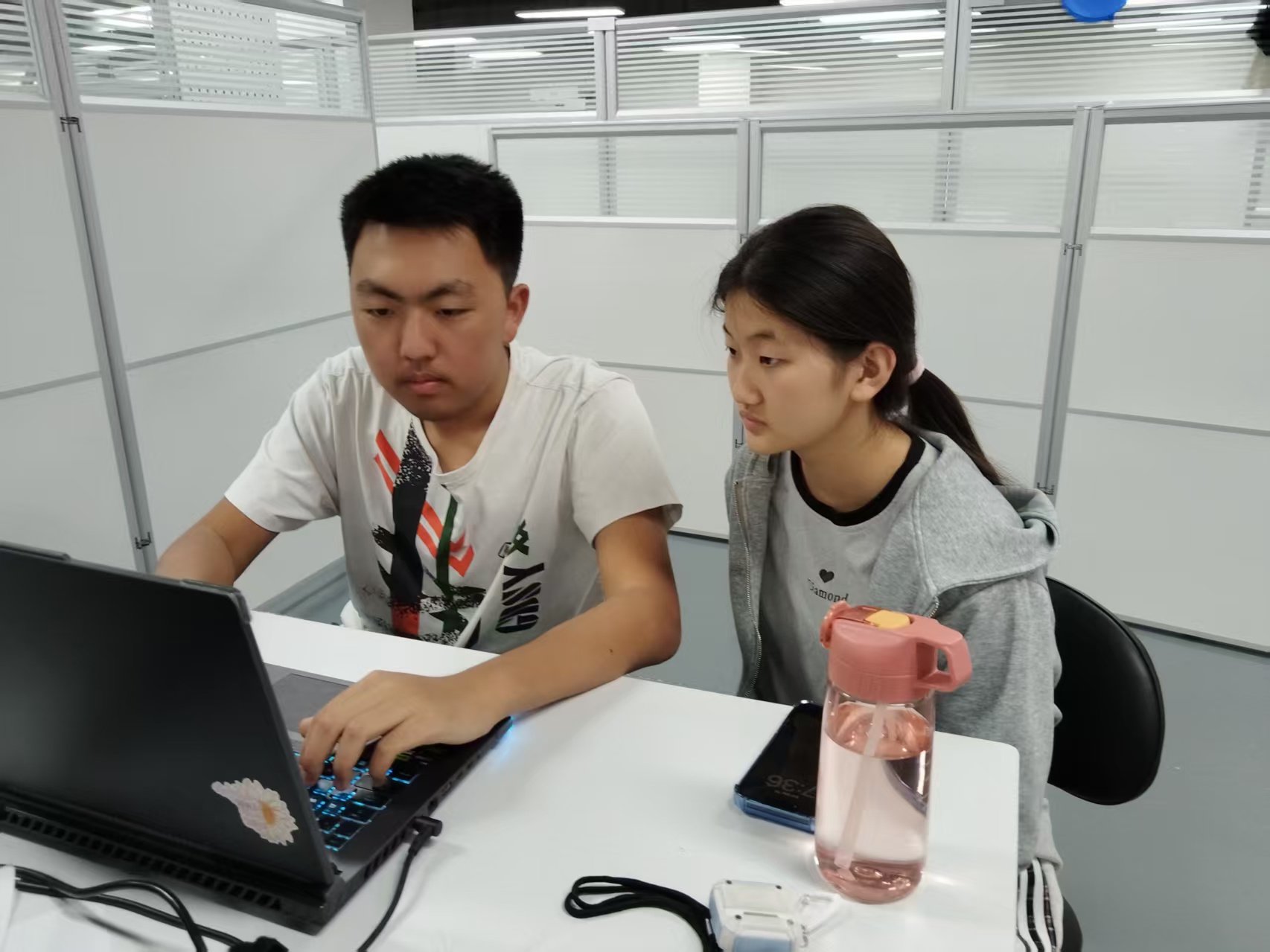 Team members collaborating beside the robot and laptop during the project.