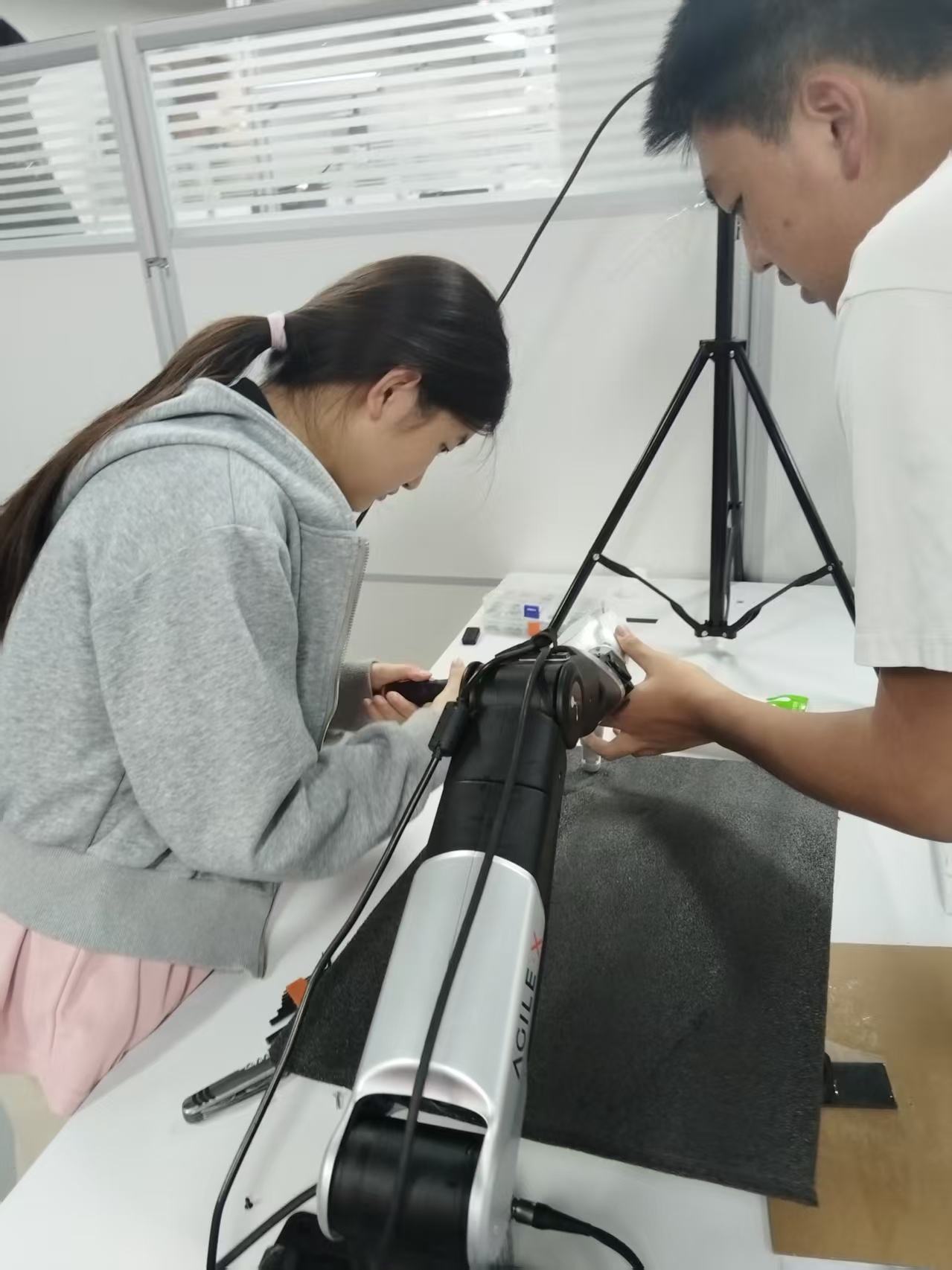Team members installing the dexterous hand on the robotic arm.