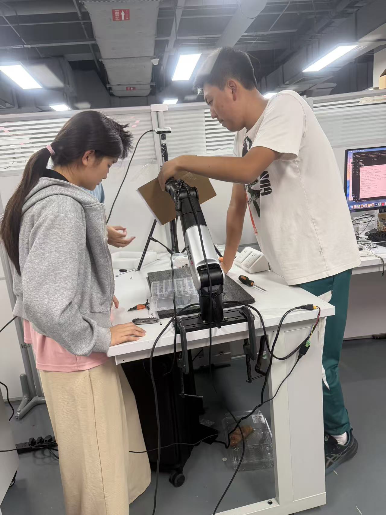 Team members positioning the calibration board in the robot workspace.